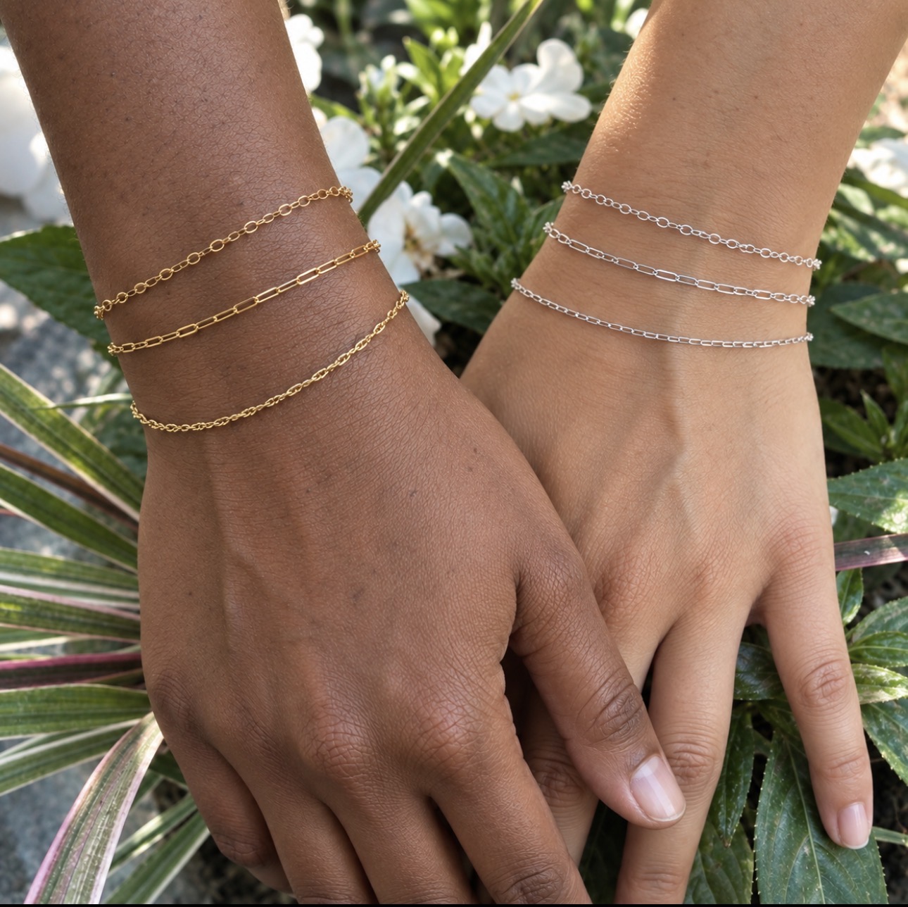 Two friends wearing layered gold and silver permanent bracelets